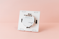 interrupteur connecté tactile de dos blanc sur un fond rose
